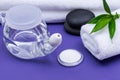 Spa purple background with Neti Pot, pile of Saline, rolled up White Towels, stacked Basalt Stones and Bamboo Leaves. Sinus wash. Royalty Free Stock Photo