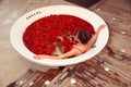 Spa Relax. Beautiful girl in jacuzzi. Bikini Woman lying in round bath with red rose petals. Health And Beauty. Sexy Girl in red Royalty Free Stock Photo
