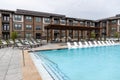 Spa resort with many sun loungers, swimming pool, rooftop dining area. Big brown building on Royalty Free Stock Photo