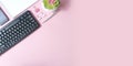 Feminine business concept. Modern office flatlay with pc keyboard, smartphone, empty notebook and succulent on pink background.