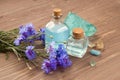 SPA salon, aromatherapy or cosmetics concept. Blue cornflower flower water in glass bottles and bath salt on wooden brown table