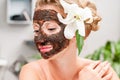 Spa salon. Beautiful woman with chocolate facial mask at beauty salon Royalty Free Stock Photo