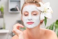 Spa salon. Beautiful woman with clay facial mask at beauty salon Royalty Free Stock Photo