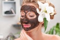 Spa salon. Beautiful woman with coffee facial mask at beauty salon Royalty Free Stock Photo