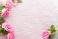 Spa salt crystals and  pink roses with green leaves.  Flat lay Royalty Free Stock Photo