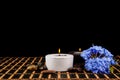 Spa scene - aromatherapy candle and flower on a black backgroun