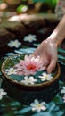 Spa serenity Female hand and flower in a serene water setting
