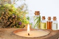 Spa set with burning candle, essential oils in bottles, herbs and flower