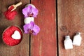 Spa set with red bath salt, orchid and towel flowers, lotion and soap on a wooden background Royalty Free Stock Photo