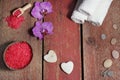 Spa set on red boards with hearts made of stone for massage, bath salt, towels and pink orchid flowers Royalty Free Stock Photo