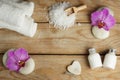 Spa set on a wooden table with hearts made of stone for massage, bath salt, towels and pink orchid flowers and body Royalty Free Stock Photo