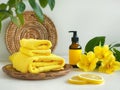 Spa setting with bright yellow towels and fresh lemon slices, essential oil and yellow exotic flowers Royalty Free Stock Photo