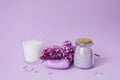 Spa setting with lilac flowers. Sea salt in a glass jar, soap and candle on the background Royalty Free Stock Photo