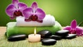 A spa setting with a lit candle, towels, and purple orchids Royalty Free Stock Photo