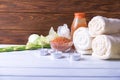 Spa setting with natural olive bath boamb, sea salt, scrub, flowers, towels and candles. On a white wooden table. with copy