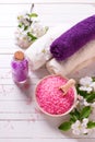 Spa setting. Sea salt in bowl, towels and flowers on white wo Royalty Free Stock Photo