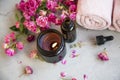 Spa still life with candle and roses, essential oil bottle, top view of beauty and spa products, spa and wellness products Royalty Free Stock Photo