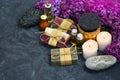 SPA still life with handmade soap, aroma candles, lilac flowers, aromatic oils and stones on the dark background Royalty Free Stock Photo