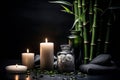 Spa still life with lit candles. stones, bamboo tray, group of bamboo stems and black background Royalty Free Stock Photo