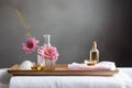 Spa setting with a white bathtub, a pink towel and a gold tray with skin care products