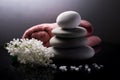 Spa still life with stack of stones, towel, sea salt and white flowers on dark background. Royalty Free Stock Photo