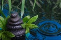 Spa still life with stone pyramid reflecting in water Royalty Free Stock Photo