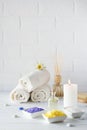 Spa still life with towel,white lily, sea salt, bath oil, sugar body scrub, massage brush Royalty Free Stock Photo