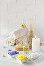 Spa still life with towel,white lily, sea salt, bath oil, sugar body scrub, massage brush Royalty Free Stock Photo
