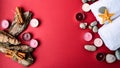 Spa still life treatment with candles, stones, sea shells starfish cinnamon bark and towels on red background Royalty Free Stock Photo