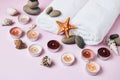 Spa still life treatment with candles, stones, sea shells starfish and towels on pink background Royalty Free Stock Photo