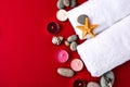 Spa still life treatment with candles, stones, sea shells starfish and towels on red background Royalty Free Stock Photo