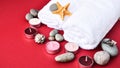 Spa still life treatment with candles, stones, sea shells starfish and towels on red background Royalty Free Stock Photo