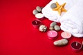 Spa still life treatment with candles, stones, sea shells starfish and towels on red background Royalty Free Stock Photo