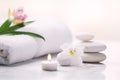 Spa still life of white towels, candles, and flowers in a Zen spa setting to promote relaxation, wellness and healthy self-care