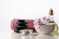 Spa still life with zen stones, orchid flower in bowl, candle, bottle with oil and towel. Royalty Free Stock Photo