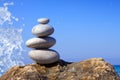 Spa stones balance on beach and sea waves crashing .