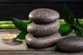 Spa stones, bamboo and burning candle on wooden table, closeup Royalty Free Stock Photo