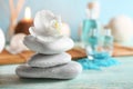 Spa stones with beautiful flower on wooden table Royalty Free Stock Photo