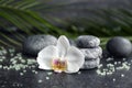 Spa stones and beautiful orchid flower on grey table Royalty Free Stock Photo