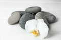 Spa stones and beautiful orchid flower on white table Royalty Free Stock Photo