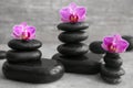 Spa stones and beautiful orchid flowers on grey table Royalty Free Stock Photo
