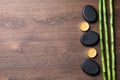 Spa stones, burning candles and bamboo stems on wooden table, flat lay. Space for text Royalty Free Stock Photo