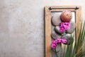 with spa stones, candle and orchid flowers on grey background, top view. Space for text Royalty Free Stock Photo