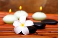 Spa stones, candles and frangipani flower Royalty Free Stock Photo