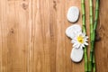 Spa stones, flower and bamboo stems on wooden table, flat lay. Space for text Royalty Free Stock Photo