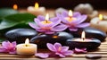 Spa stones with flowers and candles on bamboo mat, closeup Royalty Free Stock Photo