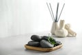 Spa stones and green leaf on light grey table. Space for text Royalty Free Stock Photo