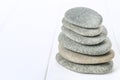 From spa stones make Balances pyramids on white wooden background. Royalty Free Stock Photo