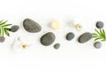 Spa stones, palm leaves, flower white orchid, candle and zen like grey stones on white background. Flat lay, top view Royalty Free Stock Photo