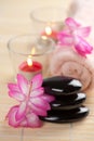 Spa stones and pink flowers over bamboo mat Royalty Free Stock Photo